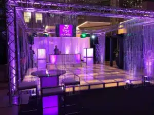 Light-up dance floor rental setup featuring a premium event space with purple lighting, bar area, and modern seating arrangements, ideal for immersive environments and events.